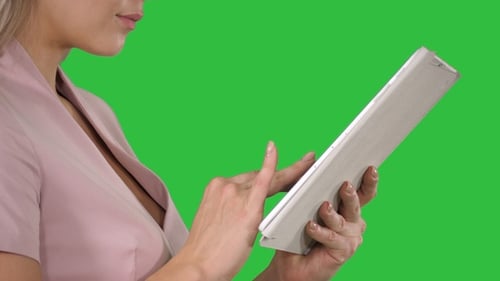 Female hands using tablet on a Green Screen, Chroma Key.