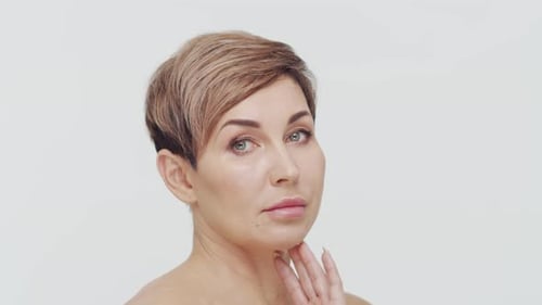 Close-up of middle aged mature woman over white background.