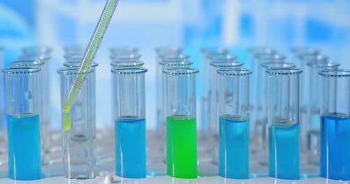 Dans un laboratoire, un scientifique muni d'une pipette analyse un liquide coloré pour en extraire l'ADN et