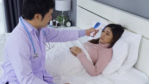 doctor using infrared forehead thermometer (thermometer gun) to measuring temperature of sick woman