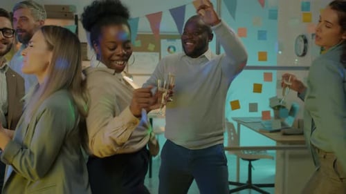 Grupo diversificado de funcionários dançando no escritório curtindo uma festa noturna com champanhe