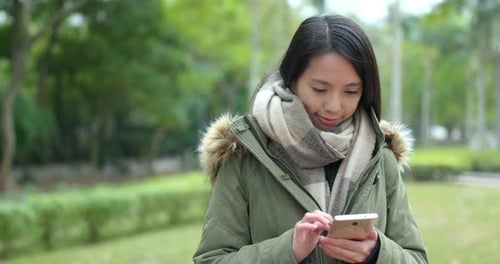 Woman use of mobile phone in park