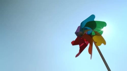 Spinning Colorful Pinwheel Against Blue Sky