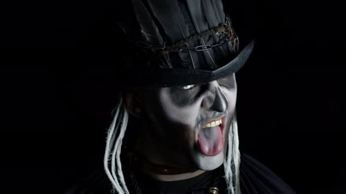 Frightening Man in Skeleton Halloween Costume Appearing From Darkness When Light Falls on Him