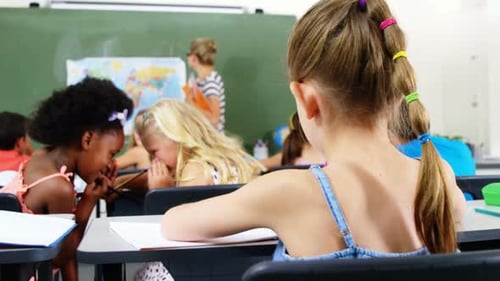 Young Students In Elementary School Classroom Writing