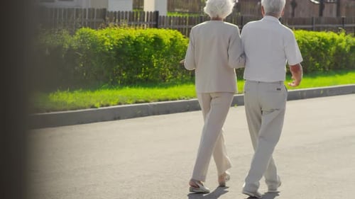 Elderly Couple Walking Outdoors on Summer Day