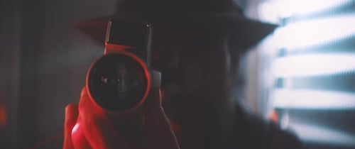 Close up of man with vintage camera in red light