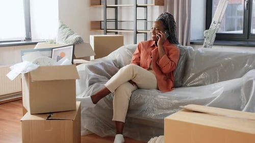 Woman Talking on Phone Sitting on Plastic-Covered Sofa