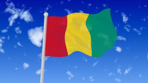 Waving National Flag of Guinea against a Cloudy Blue Sky