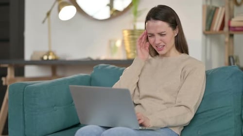 Young Woman with Laptop Having Headache on Sofa