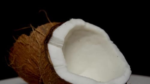Coconut Halves on White Surface, Black Background