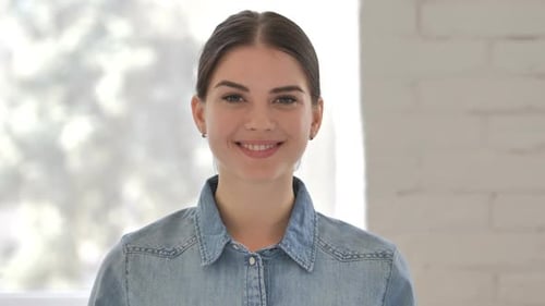 Smiling Woman Looking at Camera in Bright Room