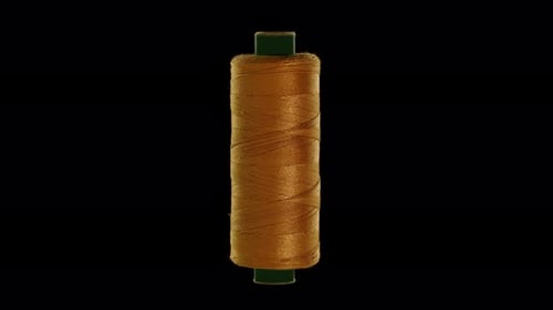 Gold Colored Sewing Thread on a Black Background