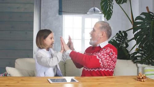 Grandfather and Granddaughter Clapping Hands in Home