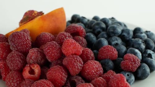 Verschiedene Früchte und Beeren auf weißem Hintergrund, Drehung um 360°. Sommerfrucht Himbeer Pfirsich,