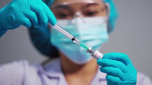 Doctor Extracts Vaccine with Syringe