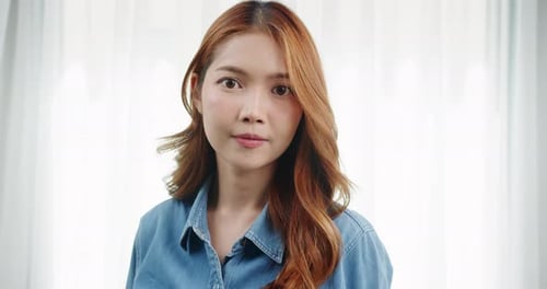 Smiling Woman with Auburn Hair Wearing Denim Shirt