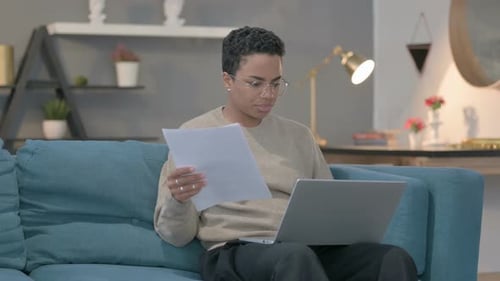 Adult Reviews Documents While Working on Laptop