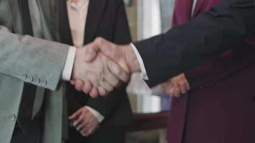 Business People Shake Hands in Agreement After Meeting
