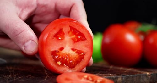 Slicing a Tomato on a Wooden Cutting Board