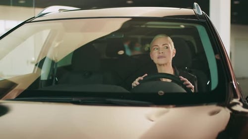 Young Beautiful Girl Chooses New Car at Car Dealership