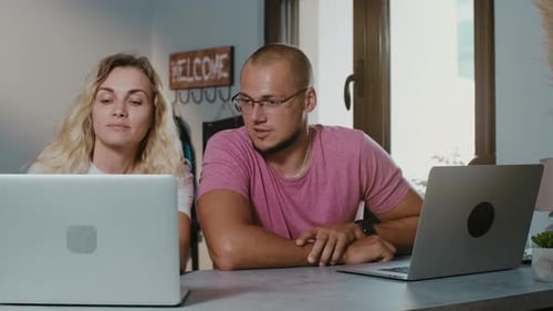 Jeune couple travaillant ensemble dans un café avec un ordinateur portable naviguant en ligne