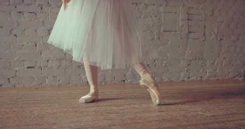 Dancer in Pointe Makes Ballet Movements with Her Feet. Close-up Below