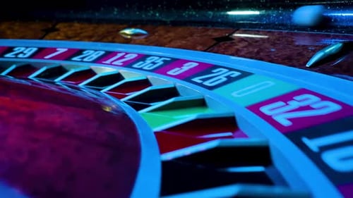 Rotating Roulette Wheel Close Up in the Rays of Blinking Neon Lights