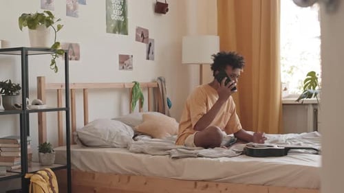 Teen Sits in Bedroom Talking on Cellphone