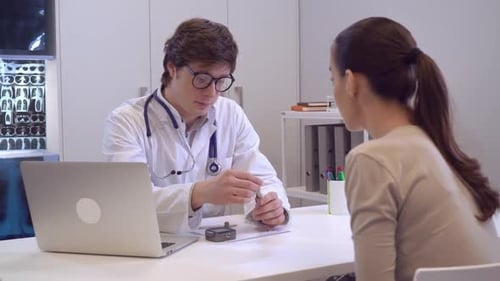 Doctor Explains Device to Patient at Desk