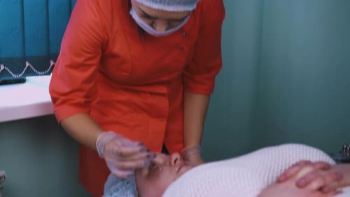 Beautician Performing Cosmetic Procedure on Female Patient