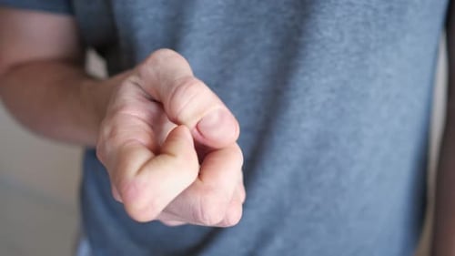 Joven se rasca una uña en un dedo que sufre de neurosis