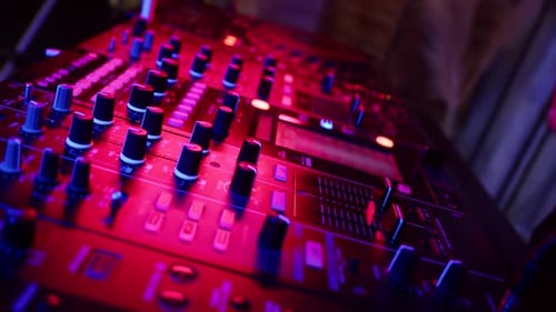 DJ drückt Tasten auf dem Mischpult, mit denen die Musik im Nachtclub bei Party Closeup gesteuert wird