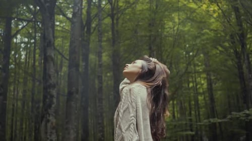 Frau schaut im Wald nach oben