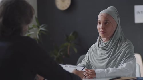 Woman Presents Resume During Corporate Job Interview