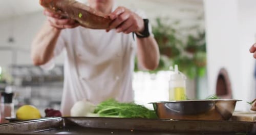 Chef Prepares Fish with Herbs and Lemon Slices