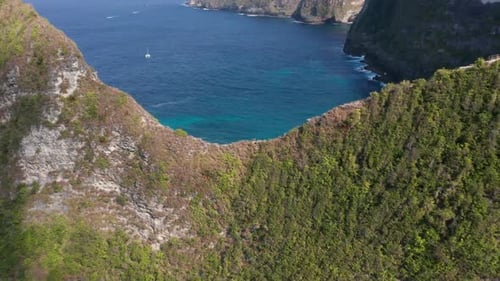 Aerial Revealing Shot of the White Sand Beach in Bali, Indonesia Beneath the Tall Cliff