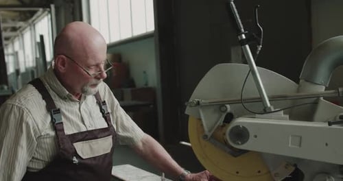 The Engineer in Glasses Examines and Touches the Lever of Machine on a Factory