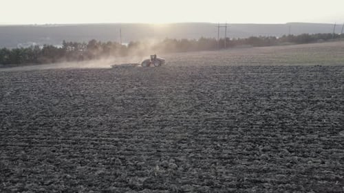 Aerial Side View of Farm Machinery Working on Cultivated Field