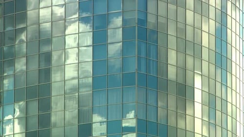 Tall Mirrored Skyscraper Reflects the Clouds Going By in a Timelapse