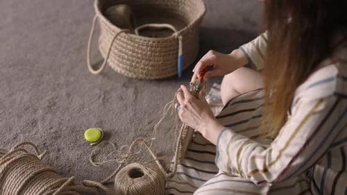 Woman Crocheting a Basket with Yarn at Home