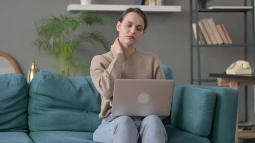 Young Woman With Neck Pain Working on Laptop
