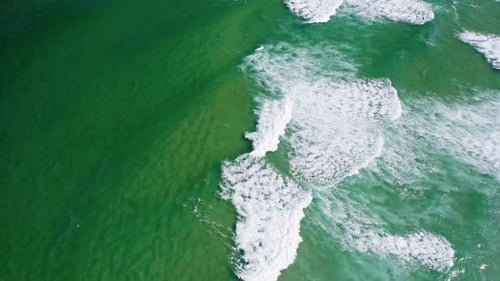Vista aérea superior das ondas de surf rolando até a costa