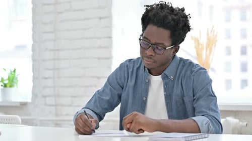 Young African Man Doing Document Work in Office