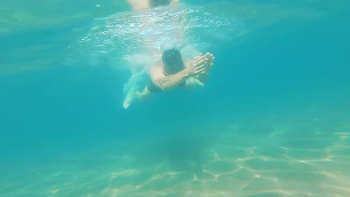 Underwater View of Man Swimming in the Ocean Clean Water Slow Motion