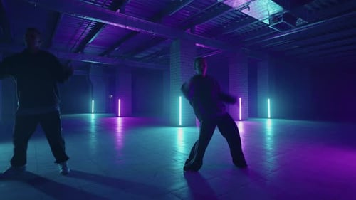 Duas dançarinas profissionais e masculinas elegantes realizando uma rotina de dança hip hop em virtual