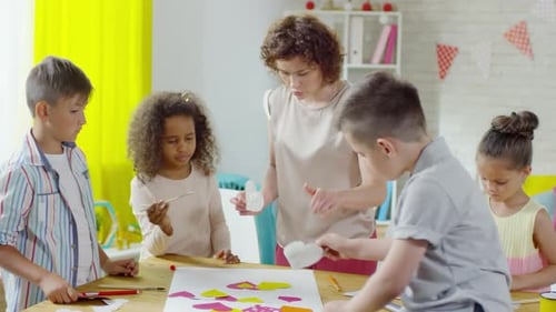 Kids Creating Colorful Collage with Teacher in Classroom