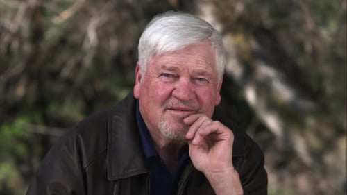 Older man lifting hand to chin resting his head