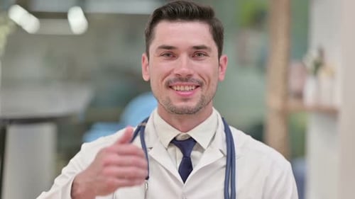 Positive Young Male Doctor Showing Thumbs Up Sign