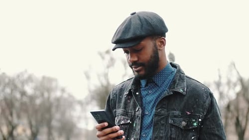 Man Using Mobile Phone Outdoors on Overcast Day